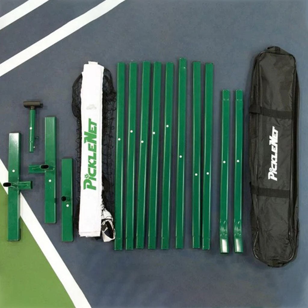 Everything in the PickleNet box laid out: green oval poles, T shaped end bases, centre support, net with centre strap, and the carry bag